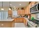 Traditional kitchen with wooden cabinets, white countertops, tile floors, and modern appliances at 1811 Tiger Creek Ave, Henderson, NV 89012