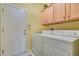 Laundry room with a full size white washer and dryer, storage cabinets, and access door to the garage at 1811 Tiger Creek Ave, Henderson, NV 89012