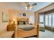 Comfortable main bedroom with a ceiling fan, wood furnishings, sitting chair, and plantation shutters at 1811 Tiger Creek Ave, Henderson, NV 89012