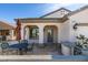 Inviting covered front porch with seating area, stone columns, and stylish outdoor lighting at 1811 Tiger Creek Ave, Henderson, NV 89012