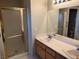 Bathroom featuring a double sink vanity, mirror, and enclosed shower with gold trim at 2223 Rugged Mesa Dr, Laughlin, NV 89029