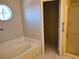 Bathroom featuring a soaking tub with tile surround and round window above at 2223 Rugged Mesa Dr, Laughlin, NV 89029