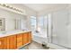 Bathroom featuring a tub, shower, double sinks, and wood cabinets at 225 Priority Point St, Henderson, NV 89012