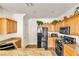 Kitchen featuring wood cabinets, granite countertops, and black appliances at 225 Priority Point St, Henderson, NV 89012