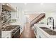 Well-lit kitchen with mosaic backsplash, stainless steel appliances, and a view of the modern staircase at 2301 W El Camino Ave, Las Vegas, NV 89102