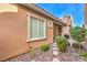 Exterior view of the backyard with a lush garden, stone pathway, and cozy patio area at 2375 Malaga Peak St, Las Vegas, NV 89135