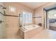 Elegant bathroom featuring a soaking tub, glass-enclosed shower, and plantation shutters at 2375 Malaga Peak St, Las Vegas, NV 89135