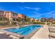 Community pool offers resort-style living with lounge chairs and well-maintained landscaping at 2375 Malaga Peak St, Las Vegas, NV 89135