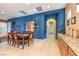 An elegant dining room features a wooden table, seating for eight, and stylish decor on the blue accent wall at 2375 Malaga Peak St, Las Vegas, NV 89135