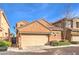 Exterior of a beige home, highlighting its architecture and well-kept landscaping at 2375 Malaga Peak St, Las Vegas, NV 89135