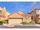 Front exterior view with a beige garage door framed by landscaping, offering curb appeal at 2375 Malaga Peak St, Las Vegas, NV 89135