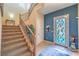 Inviting foyer with a staircase, tile flooring, and a stylish front door with stained glass window panes at 2375 Malaga Peak St, Las Vegas, NV 89135