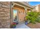 Charming front porch featuring a decorative glass door, stone accents, and lush landscaping at 2375 Malaga Peak St, Las Vegas, NV 89135