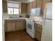 Functional kitchen showcasing wood cabinets, white appliances, and a window for natural light above the sink at 2725 S Nellis Blvd # 1158, Las Vegas, NV 89121