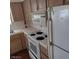 A well-lit kitchen featuring wood cabinetry, an oven, a built-in microwave, and an adjacent refrigerator at 2725 S Nellis Blvd # 1158, Las Vegas, NV 89121