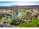 Panoramic aerial shot of the Rhodes Ranch community featuring lush landscaping, a golf course, and a serene lake at 283 Parisian Springs Ct, Las Vegas, NV 89148