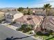 Aerial view of a charming neighborhood home with a tiled roof and lush, green landscaping at 283 Parisian Springs Ct, Las Vegas, NV 89148