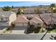 Aerial view of a charming neighborhood home with a tiled roof and lush, green landscaping at 283 Parisian Springs Ct, Las Vegas, NV 89148