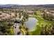 Stunning aerial view of a lush community with a golf course, lake, and palm tree-lined streets in a desert setting at 283 Parisian Springs Ct, Las Vegas, NV 89148