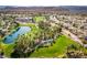 Picturesque aerial view of the Rhodes Ranch community with a golf course, lake, and lush green spaces at 283 Parisian Springs Ct, Las Vegas, NV 89148