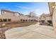 View of the backyard featuring a large concrete patio and retaining wall flower bed at 283 Parisian Springs Ct, Las Vegas, NV 89148