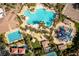 An overhead shot of a community pool with a winding design, a recreational water area, and palm tree landscaping at 283 Parisian Springs Ct, Las Vegas, NV 89148