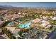 Overhead view of a community resort-style pool with play area and palm trees surrounded by residential properties at 283 Parisian Springs Ct, Las Vegas, NV 89148