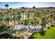 Close aerial of Rhodes Ranch community sign with palm trees, green lawns, and mountains in the background at 283 Parisian Springs Ct, Las Vegas, NV 89148