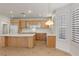 Bright kitchen featuring wooden cabinets, white countertops and backsplash, and an island with a light fixture at 283 Parisian Springs Ct, Las Vegas, NV 89148