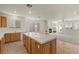 Bright kitchen with center island, tile floors, wood cabinets, and adjacent living area with fireplace at 283 Parisian Springs Ct, Las Vegas, NV 89148