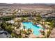 A high angle view of a community pool, water slides, tennis courts, and mountain views at 283 Parisian Springs Ct, Las Vegas, NV 89148