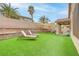 Green backyard featuring lounge chairs, artificial turf, and retaining walls, ideal for relaxation and outdoor enjoyment at 3021 Scenic Valley Way, Henderson, NV 89052