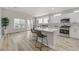 Modern kitchen with white cabinets, a breakfast bar, stainless steel appliances, and plenty of natural light at 3021 Scenic Valley Way, Henderson, NV 89052