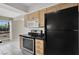 Well-lit kitchen featuring classic light-colored cabinetry and modern black appliances at 3157 Pinehurst Dr # B, Las Vegas, NV 89109