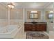 Bathroom showcasing a jetted tub, stylish vanity, mosaic tile, and attractive lighting fixtures at 3585 Tobias Ln, Las Vegas, NV 89120