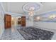 Spacious living room featuring an elegant chandelier, muraled walls, and unique tile flooring at 3585 Tobias Ln, Las Vegas, NV 89120