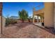 View of a gravel backyard with landscaping and a covered back patio at 3741 Lily Haven Ave, Las Vegas, NV 89120