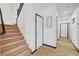 Hallway with tiled flooring, a carpeted staircase with black railing, and white walls with black trim at 3741 Lily Haven Ave, Las Vegas, NV 89120