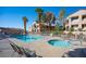 Beautiful community pool and hot tub with lounge chairs, set amongst lush tropical trees at 3883 Desert Marina Dr # 245, Laughlin, NV 89029