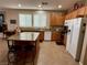 Kitchen features a central island with seating, granite countertops, wood cabinets, and stainless steel appliances at 4058 Helens Pouroff Ave, North Las Vegas, NV 89085