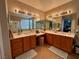 Main bathroom featuring double sinks with framed mirrors and upgraded lighting at 4058 Helens Pouroff Ave, North Las Vegas, NV 89085