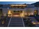 Modern home exterior showcasing a stone driveway, manicured landscaping, and architectural lighting at 41 Crested Cloud Way, Las Vegas, NV 89135