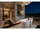 The main bathroom featuring a soaking tub, a view of the backyard, and elegant finishes at 41 Crested Cloud Way, Las Vegas, NV 89135