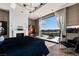 Bright main bedroom with a fireplace, hardwood floors, modern lighting, and a view of the backyard at 41 Crested Cloud Way, Las Vegas, NV 89135