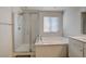 Bright bathroom showcasing the glass shower, garden tub and white cabinets at 4115 Spring Storm Ave, North Las Vegas, NV 89081