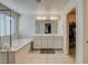 Bright bathroom featuring double sinks, glass shower, and walk-in closet access at 4115 Spring Storm Ave, North Las Vegas, NV 89081