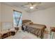 Bedroom featuring a ceiling fan, window, upholstered headboard, and accent mirror at 4115 Spring Storm Ave, North Las Vegas, NV 89081