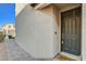 Close-up of the dark front door with modern hardware and a textured exterior wall at 4115 Spring Storm Ave, North Las Vegas, NV 89081