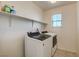 Well-lit laundry room features a modern washer and dryer and plenty of shelving space at 4115 Spring Storm Ave, North Las Vegas, NV 89081