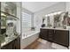 Bright bathroom featuring a soaking tub, glass block window, and double vanity at 4557 Bersaglio St, Las Vegas, NV 89135